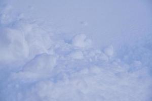 Snow surface with lumps and snowdrifts in winter. Winter snow field surface. photo