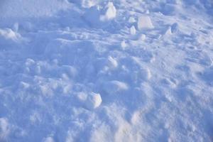 Snow surface with lumps and snowdrifts in winter. Winter snow field surface. photo