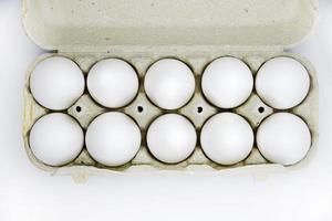 Fresh white chicken eggs in a paper bag. White eggs in a package on a white background. Eggs from the store. photo