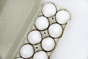 huevos de gallina blancos frescos en una bolsa de papel. huevos blancos en un paquete sobre un fondo blanco. huevos de la tienda. foto