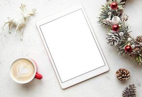 Christmas decorations and tablet on white concrete background. photo