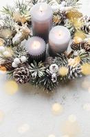 Decorated Advent wreath from fir and evergreen branches with  burning candles, tradition in the time before Christmas. photo