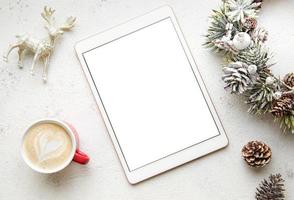 Christmas decorations and tablet on white concrete background. photo