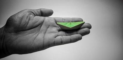 black white hand green paper boat concept freedom liberation independent hope war photo