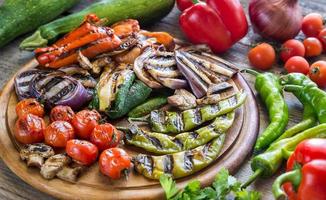 Grilled and fresh vegetables on the wooden board photo