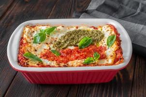 Lasagne topped with tomato sauce and pesto photo