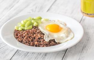 Portion of red quinoa with fried egg and celery photo