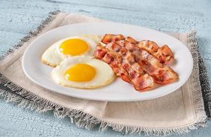 Fried eggs with bacon photo