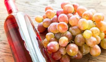 Glass of rose wine with bunch of grape photo