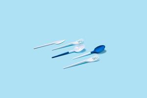 Two plastic spoons on blue background. photo