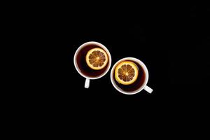 Two cups of tea on black background. photo