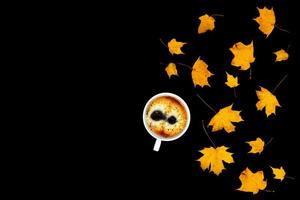 Coffee with maple leaves on black background. photo