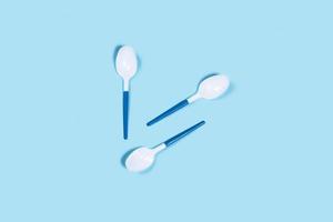 Plastic spoons on blue background. photo