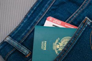 Indonesia in July 2022. An Indonesian passport and a Turkish Airlines boarding pass in a jeans pocket. photo