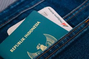 Indonesia in July 2022. An Indonesian passport and a Philippines Airlines boarding pass in a jeans pocket. photo