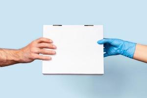 A blue background with two hands holding a box of food. photo