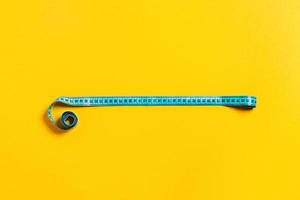 Diet concept, tape measure on yellow background. photo