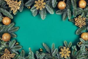 Christmas green background with fir tree and golden toys. photo