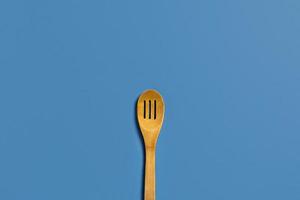 One wooden spoon on a blue background. photo