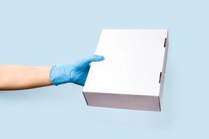 A blue background with hand holding a box. photo