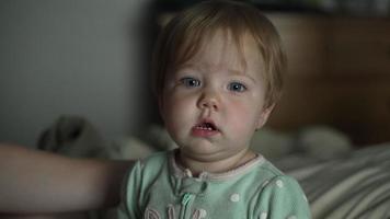 Cute Baby Girl In Pajamas Looks At Camera video