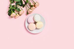 Marshmallows with roses on pink desk. photo