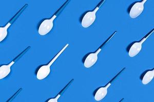 Photo with white spoons on blue background.