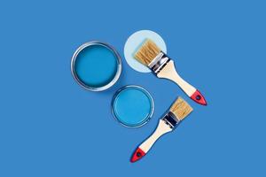 Brushes and pain cans on a blue background. photo