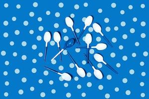 White plastic spoons on blue background. photo