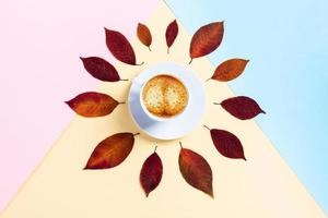 Morning autumn coffee in a white Cup on a tricolor background. photo