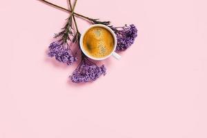 Cup of coffee with flowers on pink background. photo