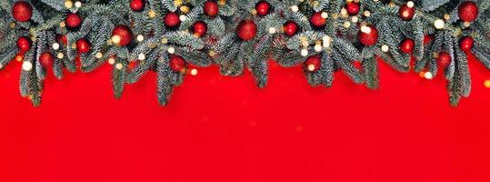 banner de navidad con bolas rojas en brunches de abeto. foto