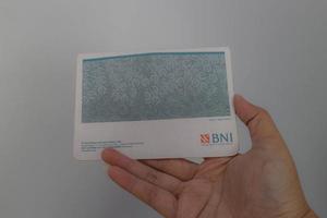 West Java, Indonesia on July 2022. A hand is holding a Bank National Indonesia account book. photo