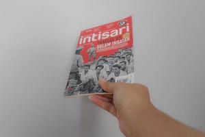 West Java, Indonesia on July 2022. A hand is holding an Indonesian magazine, namely Intisari, in the September 2022 issue which discusses the G 30S PKI. photo