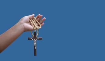 Isolated hand holding rosary and cross with clipping paths. photo