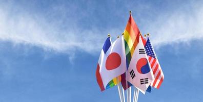 Isolated rainbow flags and flags of many countries, cloudy and bluesky background, clipping paths, concept for celebration of lgbtqai genders in pride month around the world, soft and selective focus. photo