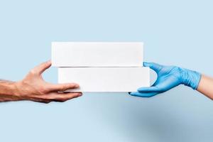 A blue background with two hands holding a box of food. photo