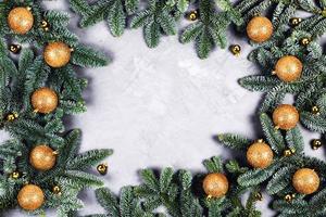 Christmas card with a frame of Christmas tree branches and decorations. photo