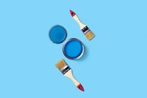 Blue background with paint jar and brushes. photo