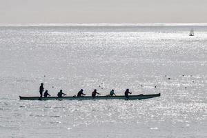 silueta de personas en una canoa al atardecer foto