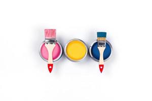 White background with three colored paint jars and brushes. photo