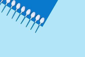 Plastic spoons on blue background. photo