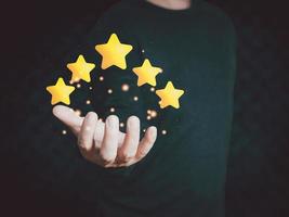 mano del cliente o cliente que sostiene las estrellas para completar cinco estrellas con espacio de copia. calificación de servicio, otorgando una calificación de cinco estrellas. concepto de satisfacción. foto