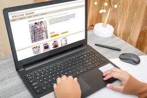 A woman shopping online, which is paying online, on a laptop, sitting in the living room, at home.Digital money transfer, banking and e commerce concept. photo