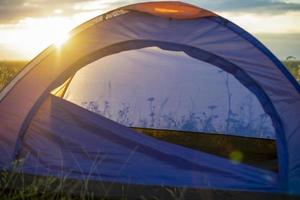 Tourist tent on mountain landscape at sunset in summer. Tourism Adventure travel lifestyle concept. photo