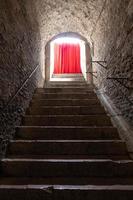 Old corridor with red curtain at the end. Concept for mystery, gothic, escape, hope. photo