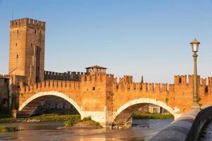 Verona, Italy. Castelvecchio bridge on Adige river. Old castle sightseeing at sunrise. photo