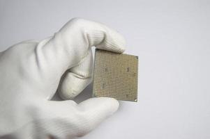 Picture of CPU chip in hand, CPU with many pins, on white background. photo