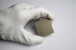 Picture of CPU chip in hand, CPU with many pins, on white background. photo