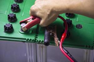 Top view, mechanic working with battery tweezers photo